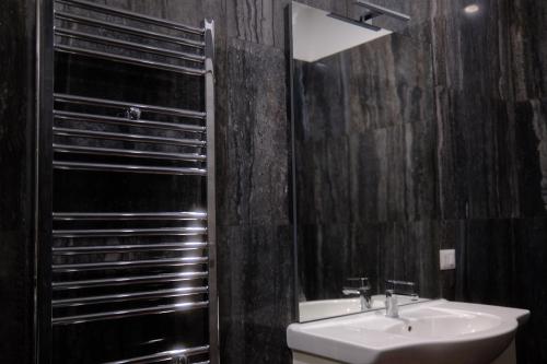 uma casa de banho com um lavatório e um espelho em Comodo appartamento em Baranzate