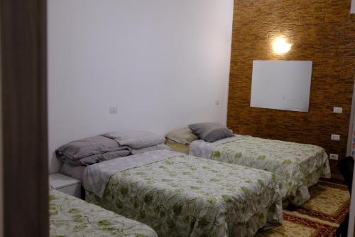um quarto com três camas num quarto em Comodo appartamento em Baranzate