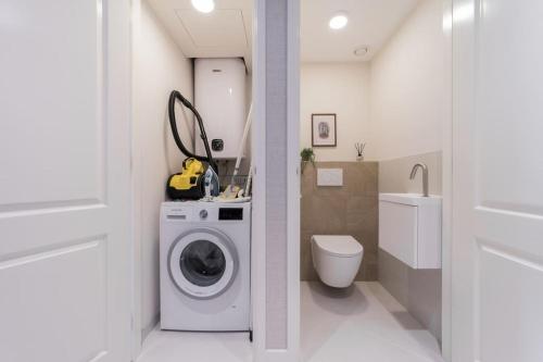 een badkamer met een wasmachine en een toilet bij Haya Seaview - 'The Casino' in Scheveningen