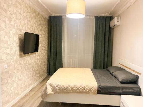 a bedroom with a bed and a tv on a wall at Central City 1 Bedroom in Chişinău