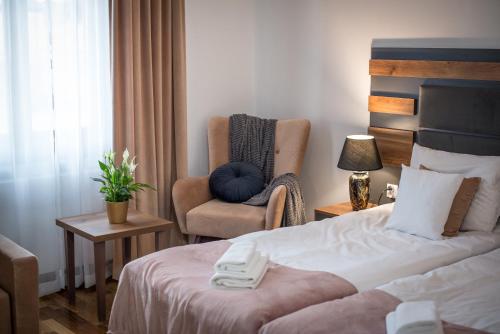 Habitación de hotel con cama y silla en Hotel Sukcesor, en Zamość