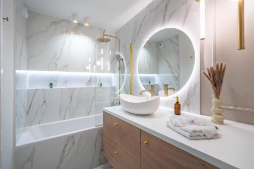 a white bathroom with a sink and a mirror at Luxueux appartement - Vue mer - Parking - AZ in Beausoleil
