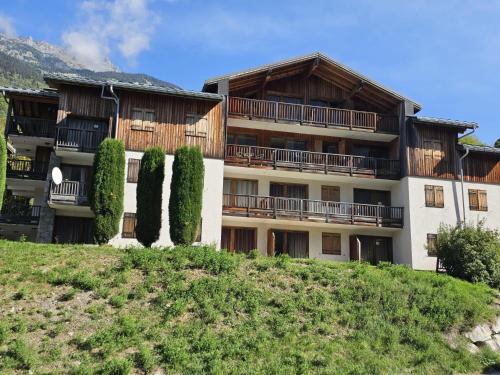 un gran edificio con árboles delante de él en Les 3 Vallées - Hameau des eaux d'Orelle - Appartement 003, en Orelle