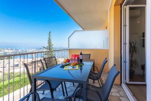 une table bleue et des chaises sur un balcon dans l'établissement LE MONT ALBAN AP4360 By Riviera Holiday Homes, à Villefranche-sur-Mer