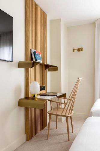 a bedroom with a desk and a chair at Le Plessis Grand Hotel in Le Plessis-Robinson