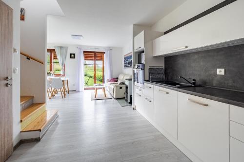 kuchnia z białymi szafkami i czarnym blatem w obiekcie Apartmán Jasmin w mieście Frymburk