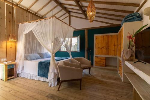 Schlafzimmer mit einem Bett mit Moskitonetz in der Unterkunft Casa Nuhatê Trancoso - Praia do Espelho in Praia do Espelho