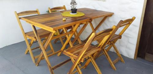 drewniany stół i krzesła z doniczką w obiekcie Chale Canoa Beach w mieście Canoa Quebrada