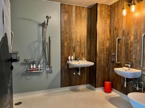 een badkamer met 2 wastafels en houten wanden bij Bike & Boot Inns Peak District - Leisure Hotels for Now in Castleton