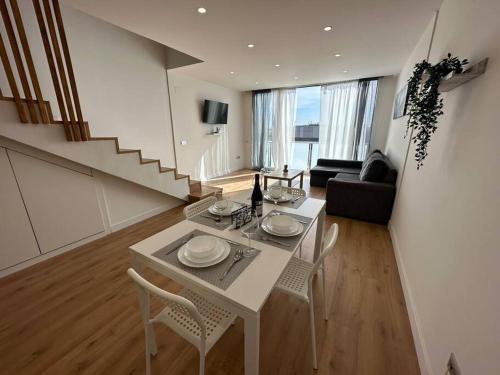 Madrid Living - Cuatro Vientos في مدريد: غرفة معيشة مع طاولة وكراسي بيضاء