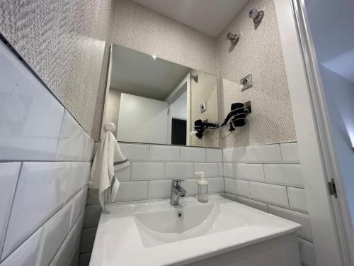 La salle de bains blanche est pourvue d'un lavabo et d'un miroir. dans l'établissement Madrid Living - Cuatro Vientos, à Madrid