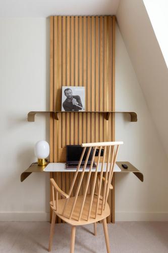 a wooden desk with a chair in a room at Le Plessis Grand Hotel in Le Plessis-Robinson