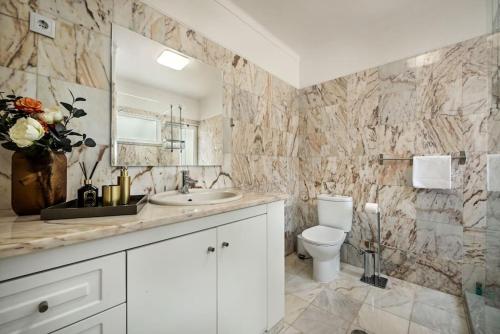 a bathroom with a toilet and a sink and a mirror at Villa Aladdin in Olhos de Água