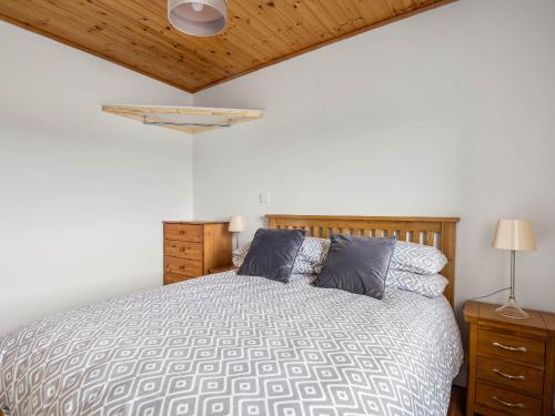 a bedroom with a bed and a wooden ceiling at Lake House Mannin, Ballyconneely in Ballyconneely