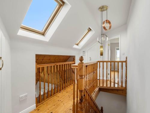 a wooden staircase in a house with a skylight at Lake House Mannin, Ballyconneely in Ballyconneely