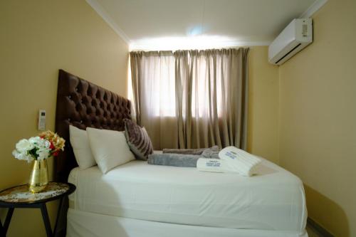 a bedroom with a large white bed with a window at Home Life Guesthouse in Midrand
