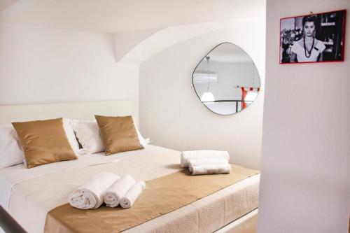 um quarto com uma cama com um espelho na parede em La Pigna em Nápoles