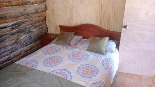 a bed with a wooden headboard and pillows on it at Estancia Don Domingo in Curicó