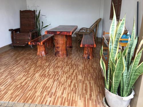 a room with two wooden benches and a potted plant at Baan Fun Dee Chiang Khan in Chiang Khan