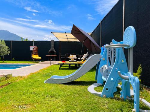 a playground equipment in the grass next to a pool at Villa Ruya by Sakina Escapes in Fethiye