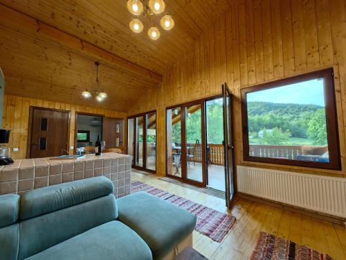 - un salon avec un canapé et une grande fenêtre dans l'établissement Raw Nature Chalet, à Crivina