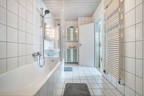 a bathroom with a tub and a sink at Ferienwohnung Große in Osterode