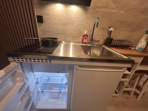 um balcão de cozinha com um lavatório e um frigorífico em Brand New Studio Apartment in Tromso - hotspot em Tromsø