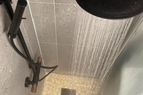 a shower with water coming out of the floor at New Aurora Hotspot - Studio Nordspissen in Tromsø