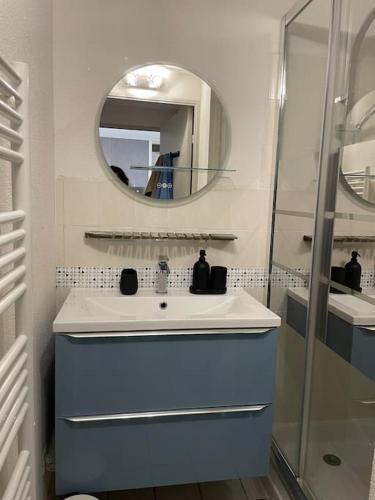 une salle de bain avec un lavabo et un miroir dans l'établissement Appartement piscine et vue mer., à Cavalaire-sur-Mer
