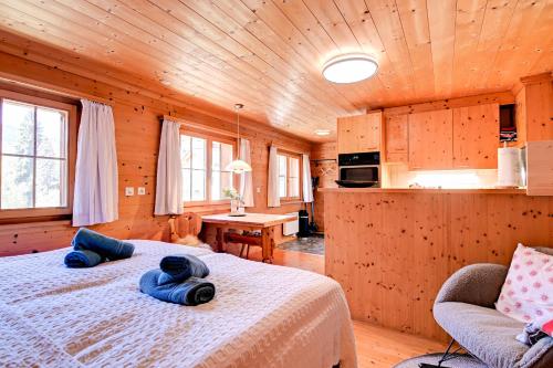 1 dormitorio con 2 camas en una cabaña de madera en Gemütliches Chalet mit schöner Aussicht, en Küblis