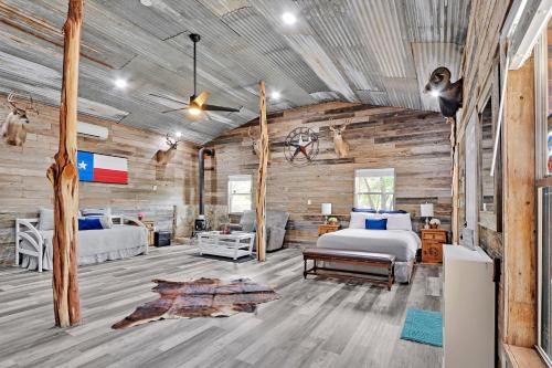 a bedroom with a bed in a room with wooden walls at Bulverde Cottage at Moonlight Getaway in Bulverde