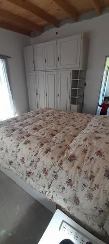 a bedroom with a bed with a floral comforter at Casa quinta 281 in La Plata