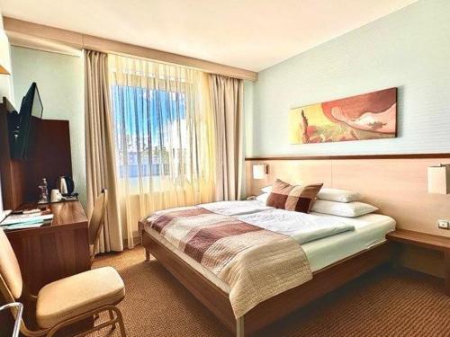 Hotel Famulus في جيور: غرفة نوم بسرير ومكتب ونافذة