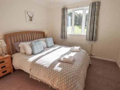 a bedroom with a bed with two towels on it at Foresters Cottage in Rusland