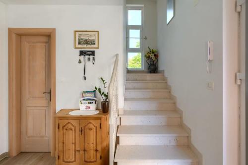 a staircase in a home with white walls and a window at Villa Alte Muhle with pool and jacuzzi in Novigrad in Novigrad Istria