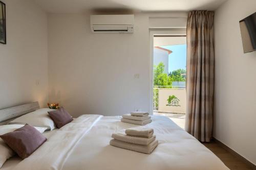 a bedroom with a large white bed with towels on it at Villa Alte Muhle with pool and jacuzzi in Novigrad in Novigrad Istria