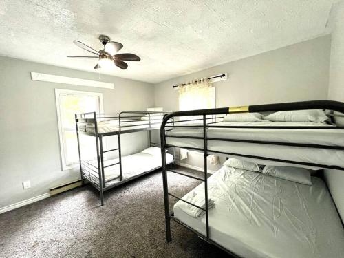 a room with three bunk beds and a ceiling fan at Basic 3 bedroom in Trenton with trailer parking in Trenton