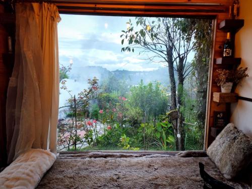 a bedroom with a large window with a view of the mountains at Romantic house on a pine hill Dalat in Xuan An