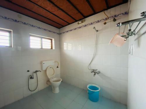 uma casa de banho com um WC e um chuveiro em Ballard Bungallow em Cochin