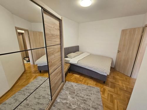 a small bedroom with a bed and a mirror at Apartman Dionis in Užice