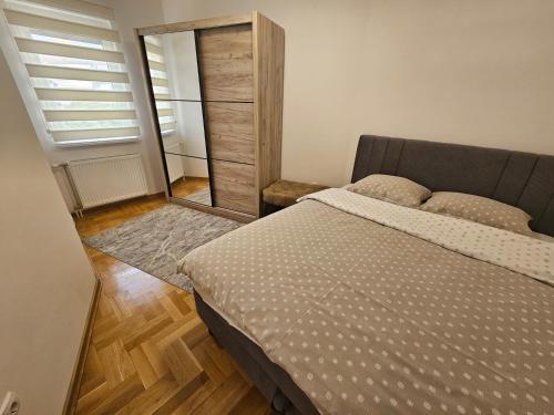 a bedroom with a bed and a mirror at Apartman Dionis in Užice