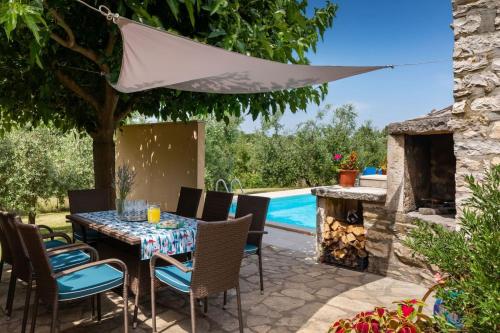 a patio with a table and chairs and a swimming pool at Villa Greis with 4 bedrooms and pool in Buje in Momjan