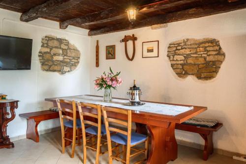 a dining room table with chairs and a vase of flowers at Villa Greis with 4 bedrooms and pool in Buje in Momjan