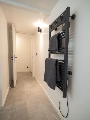 La salle de bains est pourvue d'un porte-serviettes noir sur le mur. dans l'établissement l'Instant Parfait, à Aix-en-Provence