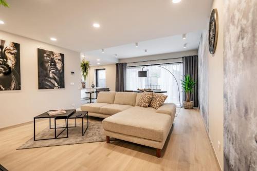 a living room with a couch and a table at L'appart Léon, avec sauna in Liège