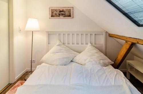 - une chambre avec un lit doté de draps et d'oreillers blancs dans l'établissement Huus an´t Koornfeld Dachgeschoss, à Osteel