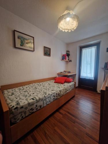 een slaapkamer met een bed met twee rode kussens erop bij L'Atelier du Temps - Casa Margherita in Courmayeur