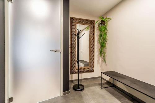 een hal met een spiegel en een bank bij L'appart Léon, avec sauna in Luik