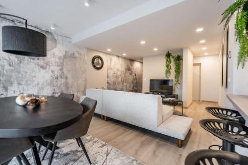 a living room with a white couch and a table at L'appart Léon, avec sauna in Liège