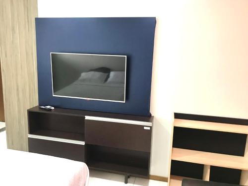 um quarto com uma televisão numa parede azul em Mobiliado e aconchegante em Belém